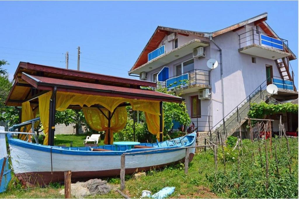 um barco sentado em frente a uma casa em Villa Rezos em Rezovo