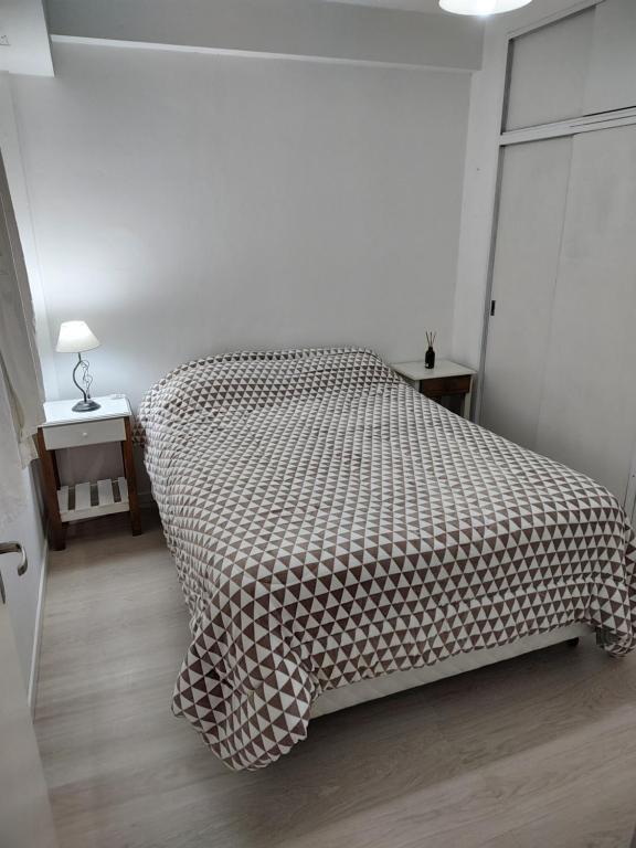 a bedroom with a bed with a checkered blanket at SANFER CENTER 2 in San Fernando