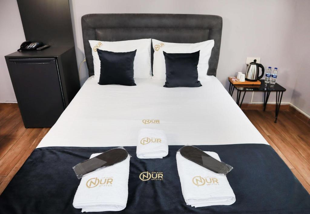 Bett mit weißer Bettwäsche und schwarzen und weißen Kissen in der Unterkunft GRAND ONUR HOTEL in Istanbul