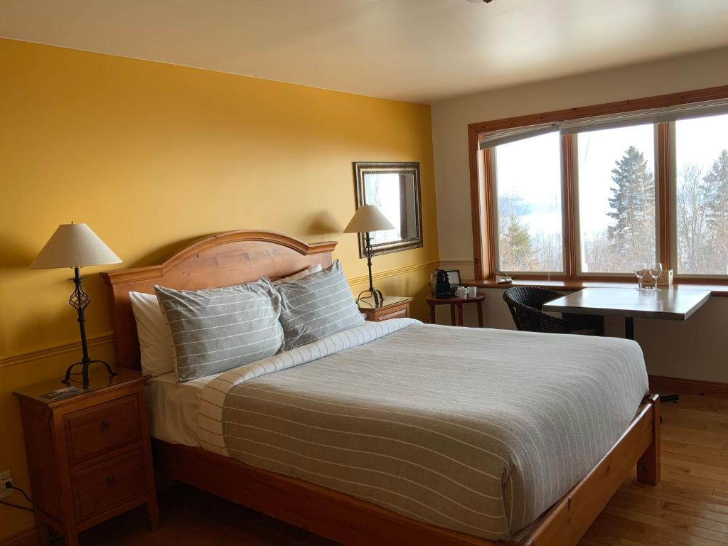Postel nebo postele na pokoji v ubytování Auberge Cap aux Corbeaux