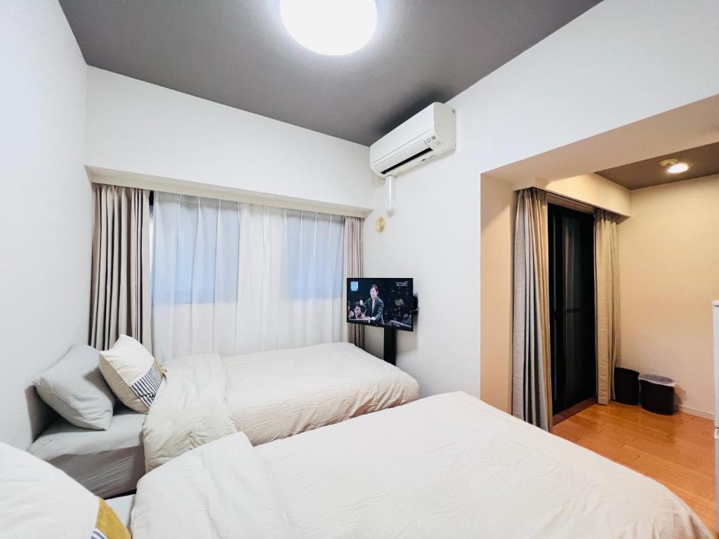 een hotelkamer met 2 bedden en een bank bij Jun KBK- 606 in Tokyo