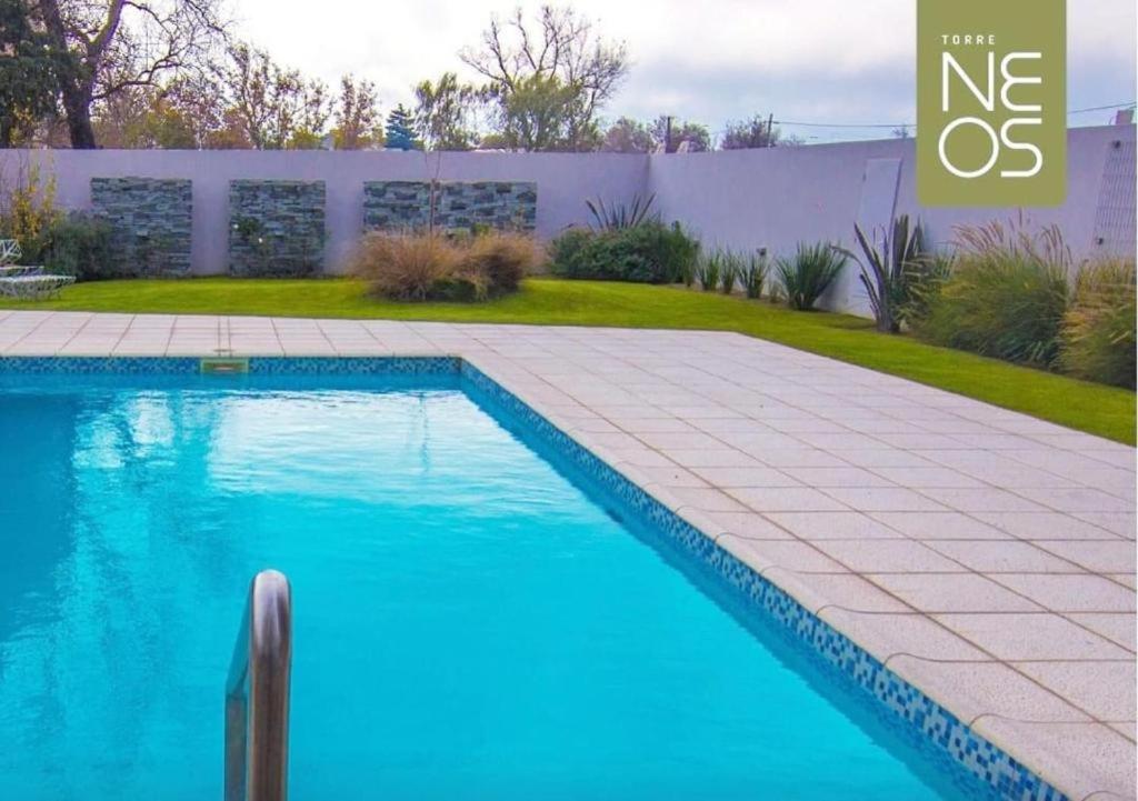 - une piscine d'eau bleue dans la cour dans l'établissement Departamento 6 piso con piscina, de 1 dormitorio, à Río Cuarto