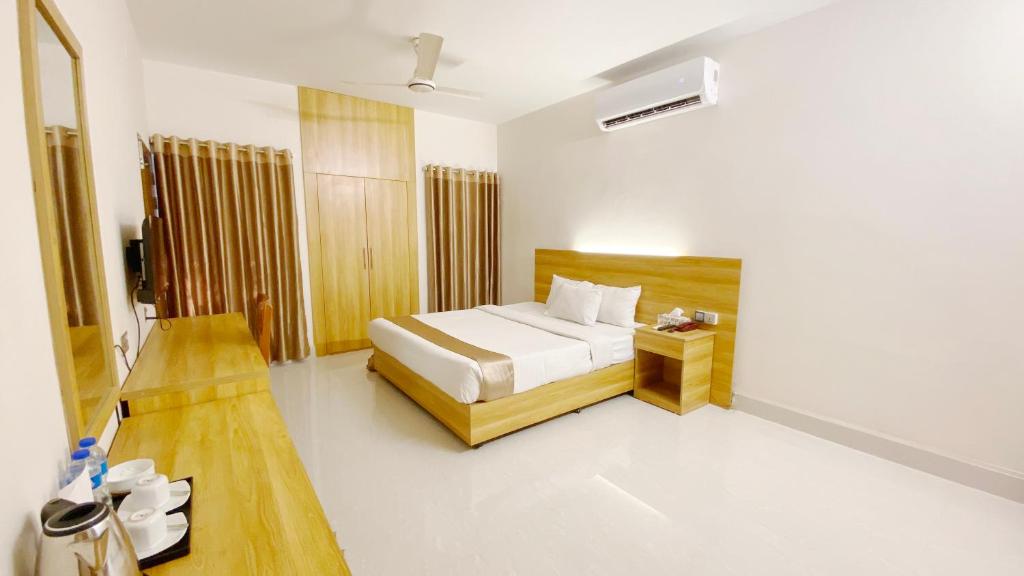 Crown Palace Residence في داكا: غرفة نوم فيها سرير وطاولة فيها