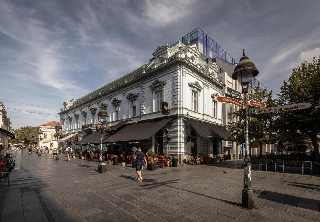 a building on a street with people walking in front of it at Maison Royale in Belgrade