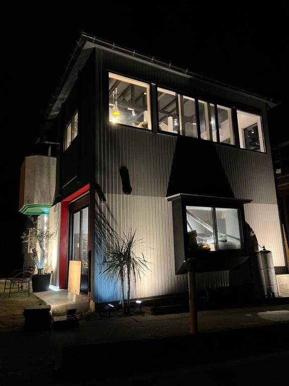 un edificio en blanco y negro con ventanas por la noche en 海宿ニシノヤ, 