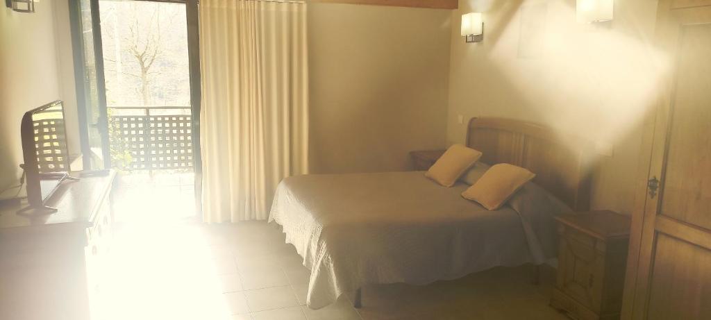 una camera da letto con un letto con due cuscini e una finestra di Estudios Ermitabarri a Zeberio