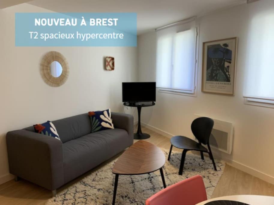 uma sala de estar com um sofá e uma televisão em Jaurès - Centre-Ville - T3 au calme em Brest