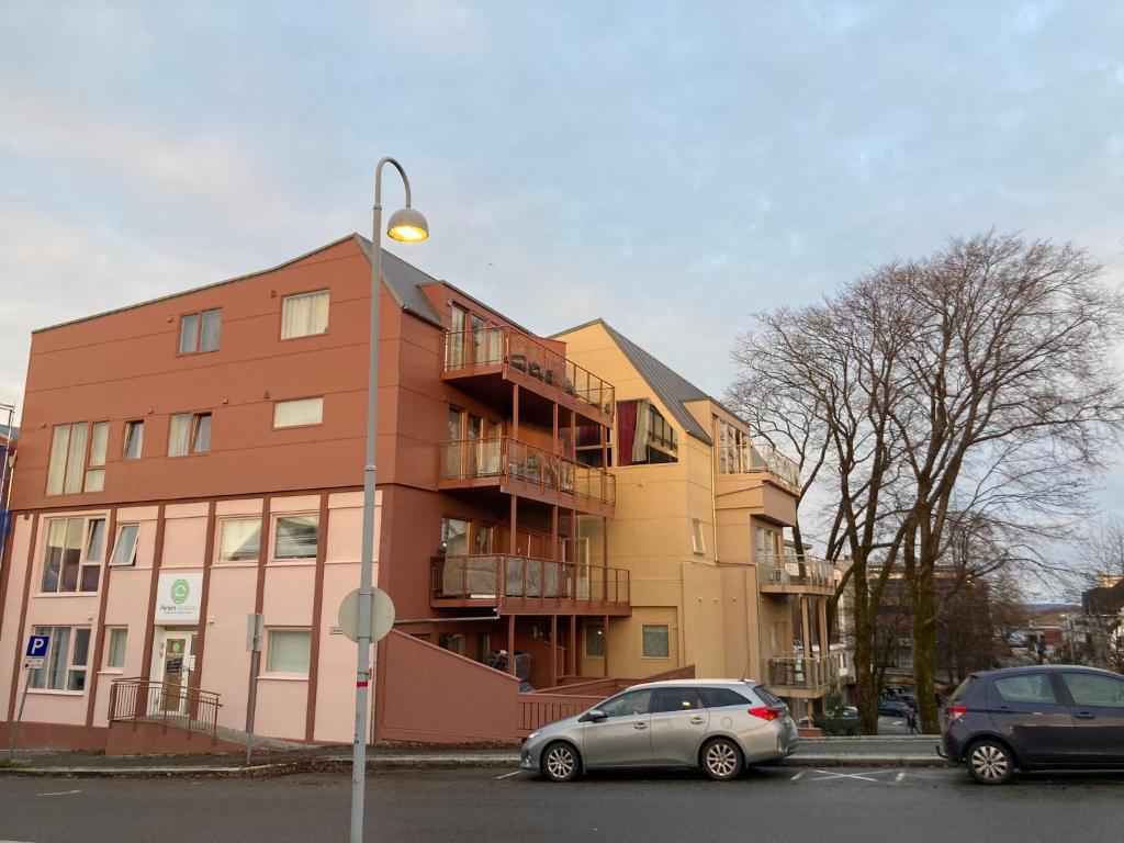 um edifício com dois carros estacionados em frente em Parken Terrasse Apartment Hotel em Kopervik
