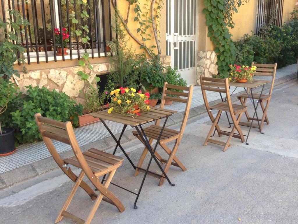 Albergue Los Chorros في ريوبار: مجموعة طاولات وكراسي عليها ورد