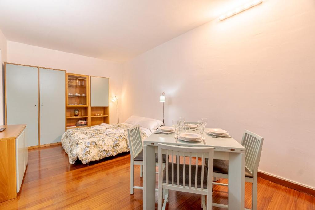 ein Esszimmer mit einem Tisch, Stühlen und einem Bett in der Unterkunft Residenza Juvarra - Exclusive Flat in Turin