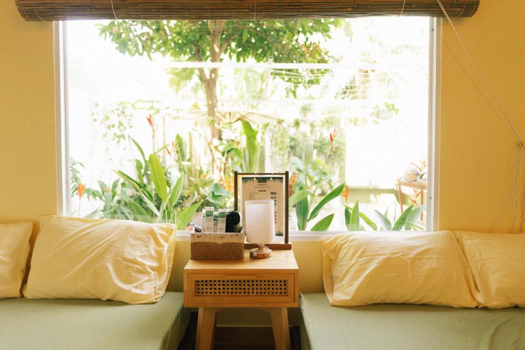 a living room with a couch and a window at Phòng Dừa - Nhà Mơ Homestay Bến Tre in Ben Tre