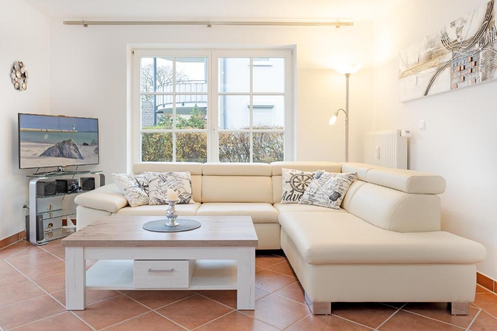 ein Wohnzimmer mit einem Sofa und einem Couchtisch in der Unterkunft Residenz Kurparkhöhe Appartement Meerzeit in Scharbeutz
