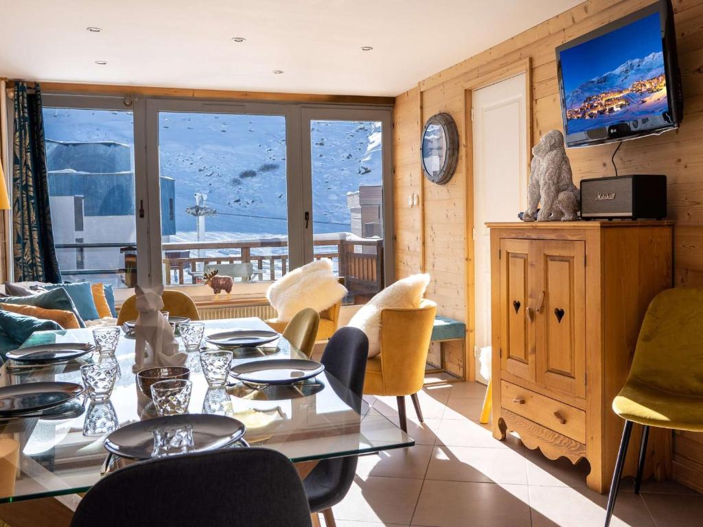 ein Esszimmer mit einem Tisch, Stühlen und einem TV in der Unterkunft Appartement Val Thorens, 4 pièces, 6 personnes - FR-1-637-28 in Val Thorens