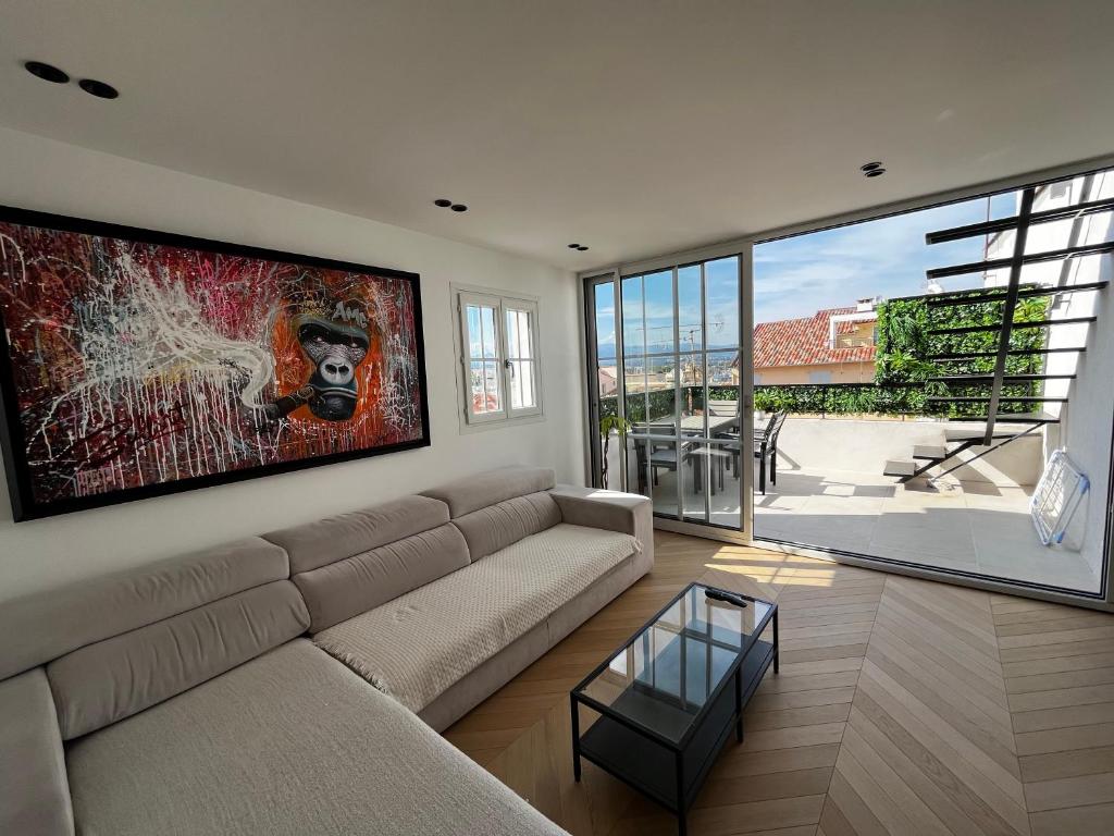 a living room with a couch and a painting on the wall at Rooftop unique vue mer / Vieil Antibes in Antibes