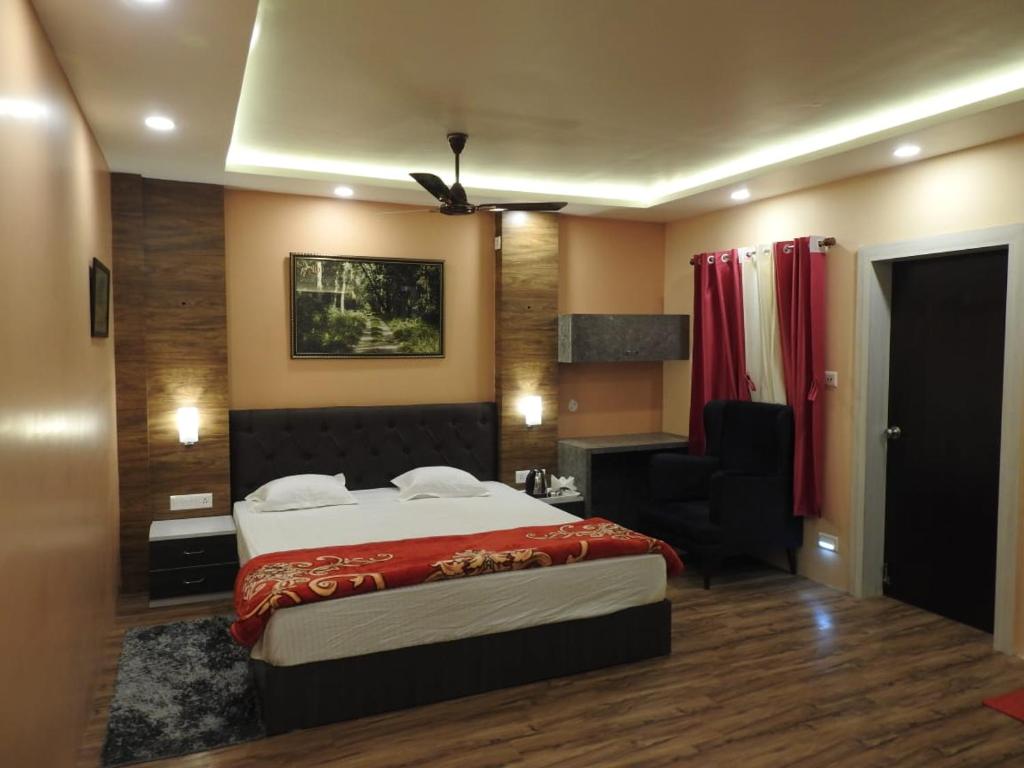 1 dormitorio con 1 cama, 1 sofá y 1 silla en hp greenland resort, en Lataguri