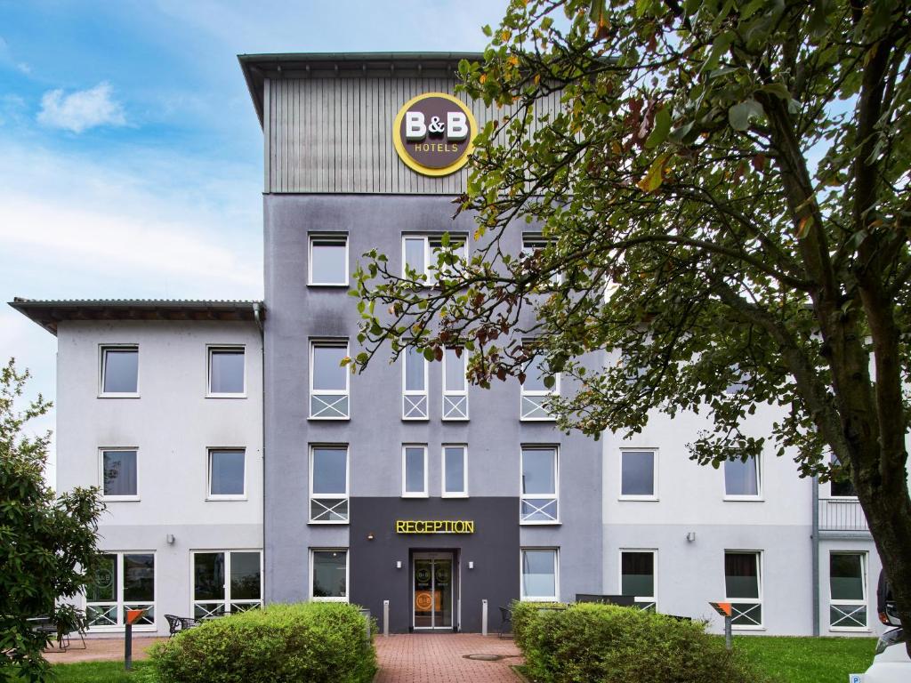 un edificio de oficinas con un letrero de bbb en él en B&B Hotel Offenbach-Süd, en Offenbach