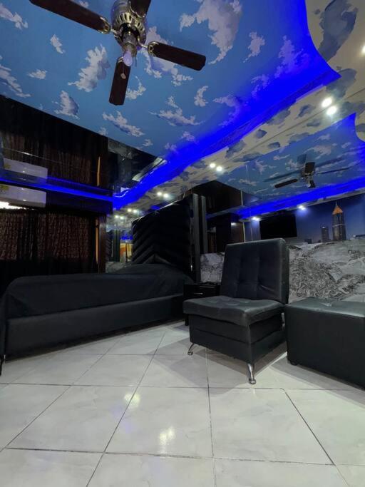 a room with couches and a ceiling with blue lights at Apartaestudio en Medellín in Medellín