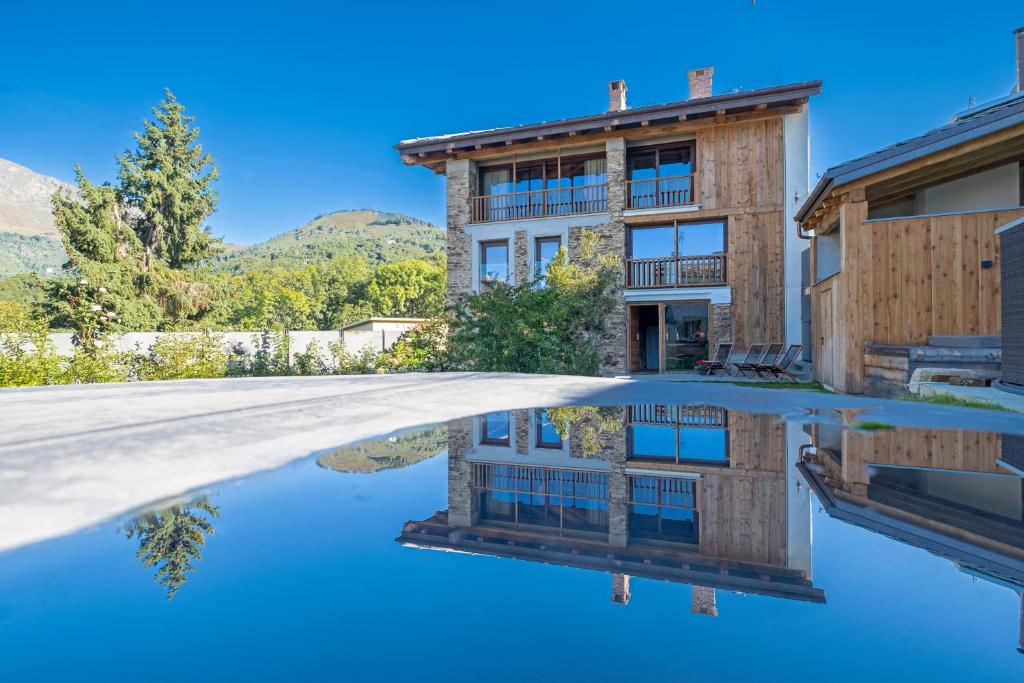 a house with a reflection in the water at L’Ozio Creativo in Castelnuovo Nigra