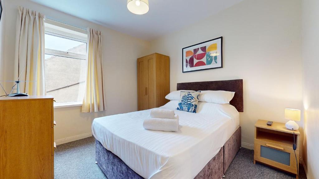 a bedroom with a large bed and a window at K Suites - Park Street in Grimsby