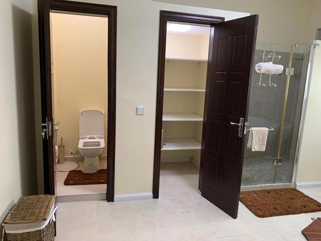 La salle de bains est pourvue de toilettes et d'une porte en verre. dans l'établissement Inak villa, à Grand Baie