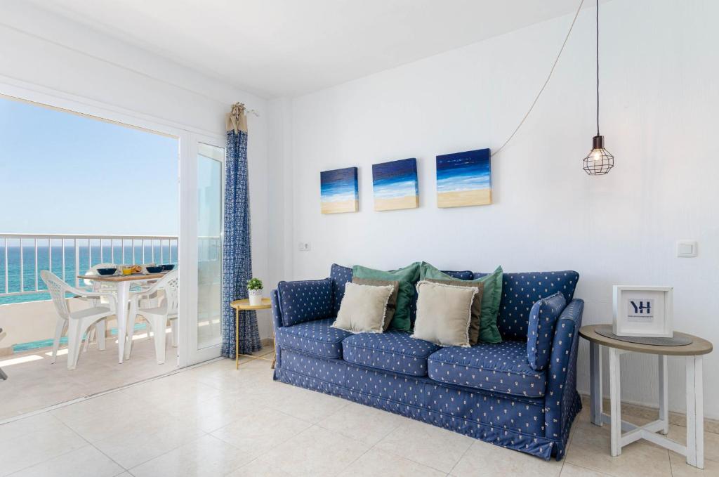 sala de estar con sofá azul y mesa en YourHouse Ocean, en Can Picafort