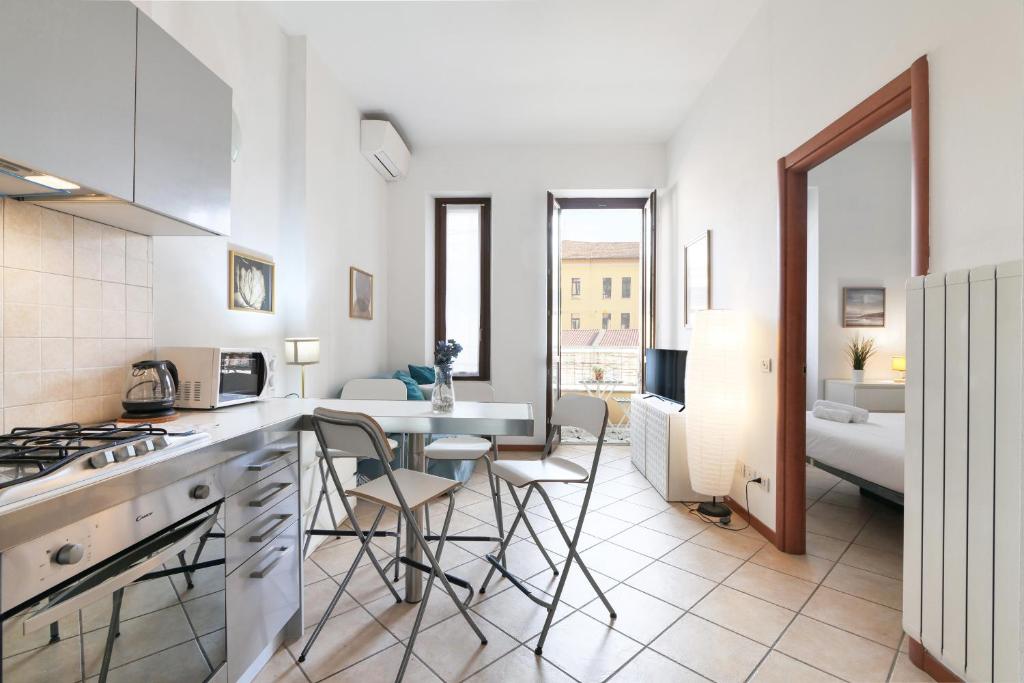 uma cozinha e sala de estar com mesa e cadeiras em PrimoPiano - Scalvini em Milão