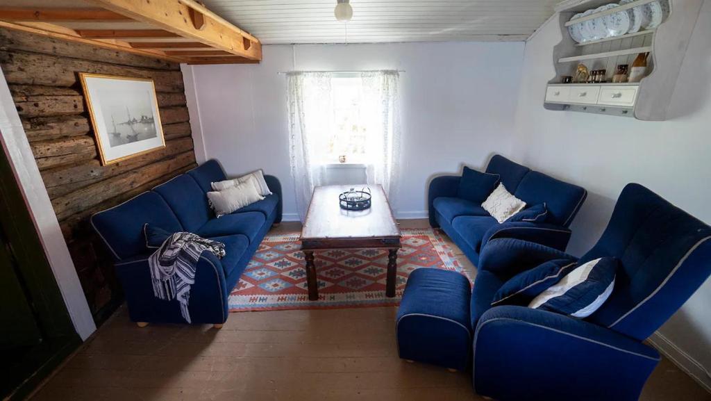 a living room with two blue couches and a table at Real fisherman's cabins in Ballstad, Lofoten - nr. 11, Johnbua in Ballstad