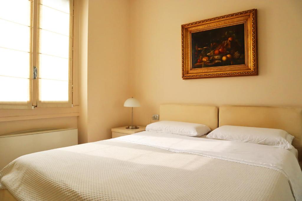 a bedroom with a bed and a painting on the wall at Repubblica Elegant Milan House in Milan