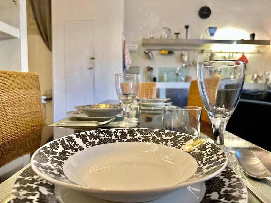 a table with a plate and wine glasses on it at Near Ponte Vecchio: central luxury flat in Florence