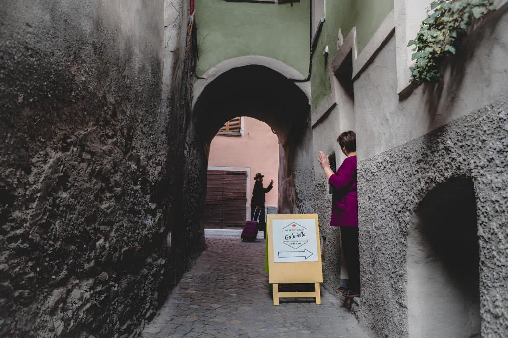 a woman taking a picture of a person standing in an alley at Bed & Breakfast Gabriella EXILLES in Exilles