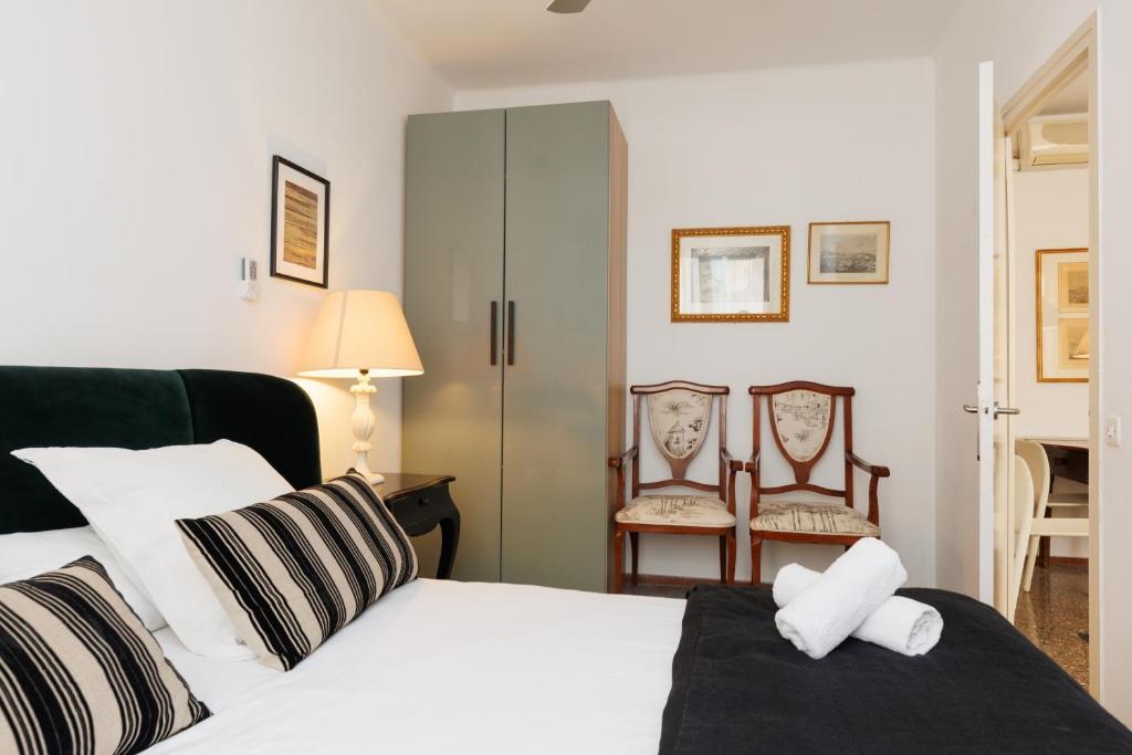 a bedroom with a bed and two chairs at Lodging Apartments Gracia 2 in Barcelona
