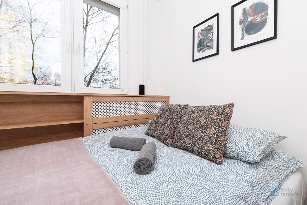 a bed with two pillows and a window in a bedroom at Baltic Breeze Apartment 3city Gdańsk by Noclegi Renters in Gdańsk