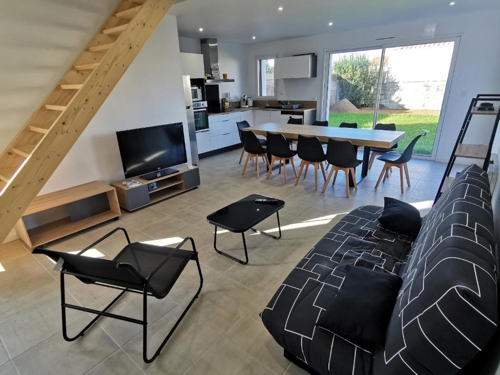 ジャール・シュル・メールにあるLa Maison Manoleのソファとテーブルと椅子のあるリビングルーム