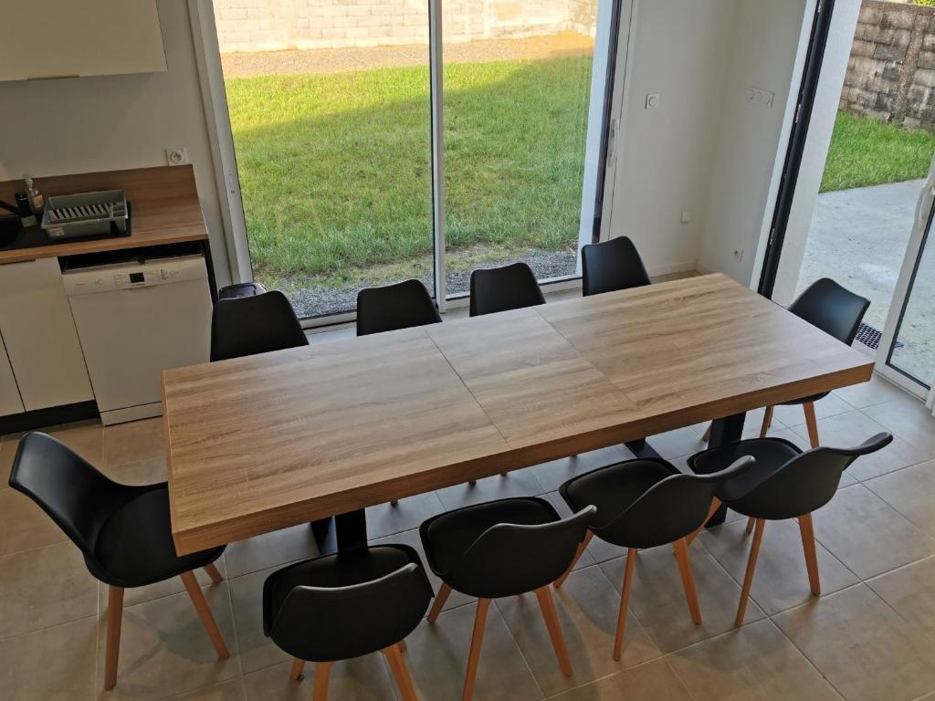 una sala de conferencias con mesa de madera y sillas en La Maison Manole, en Jard-sur-Mer