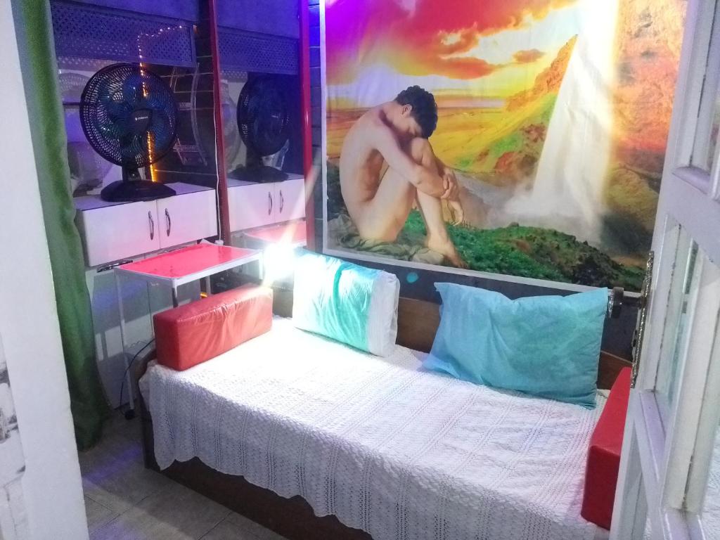 um homem deitado numa cama num quarto em Hospedagem Plenitude Café RJ no Rio de Janeiro