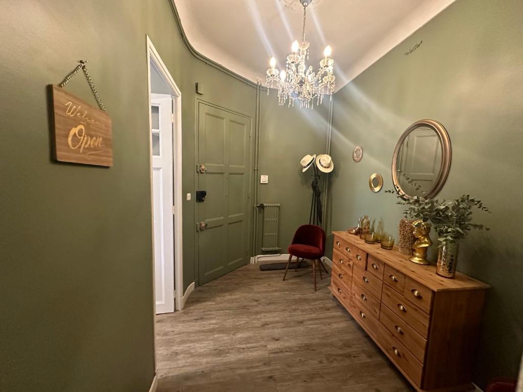 un couloir avec un miroir, une commode et un lustre dans l'établissement Le Roy, à Aix-en-Provence