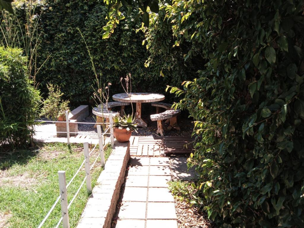 a picnic table in the middle of a garden at Casa Redonda in Monte Grande