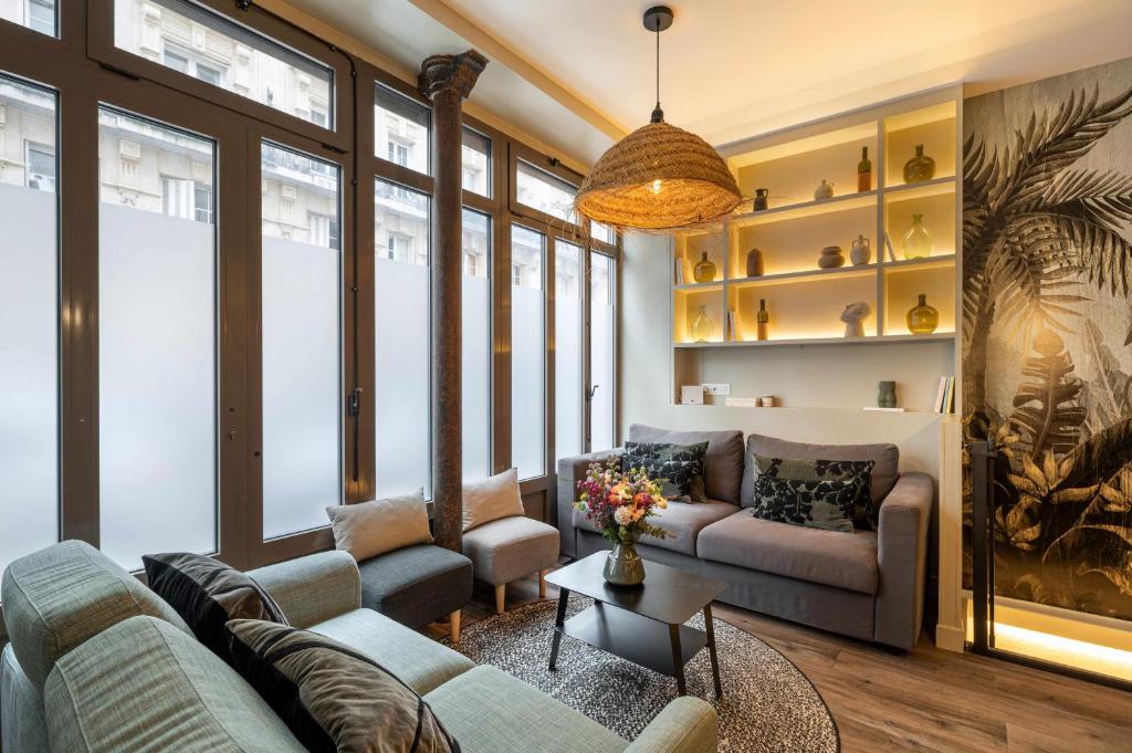 un salon avec un canapé et une table dans l'établissement The Green Loft - Eiffel Tower - Paris 15, à Paris