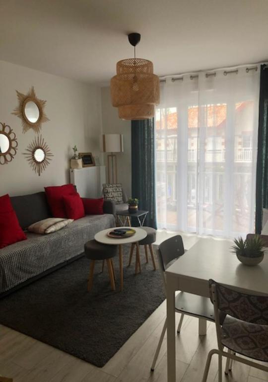 ein Wohnzimmer mit einem Sofa und einem Tisch in der Unterkunft Azurea - Charmant appartement à Andernos-les-Bains in Andernos-les-Bains