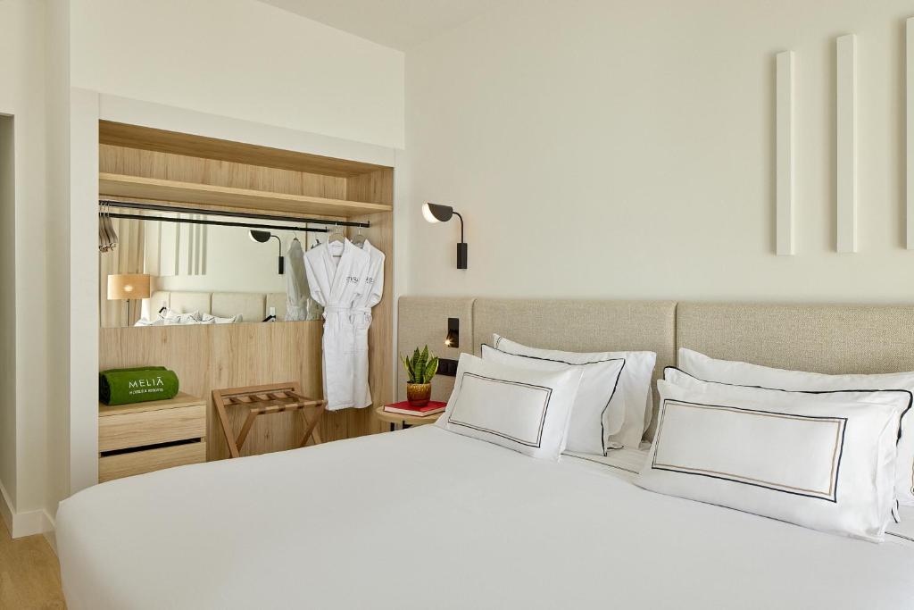 a bedroom with a large white bed with white pillows at Meliá Lloret de Mar in Lloret de Mar
