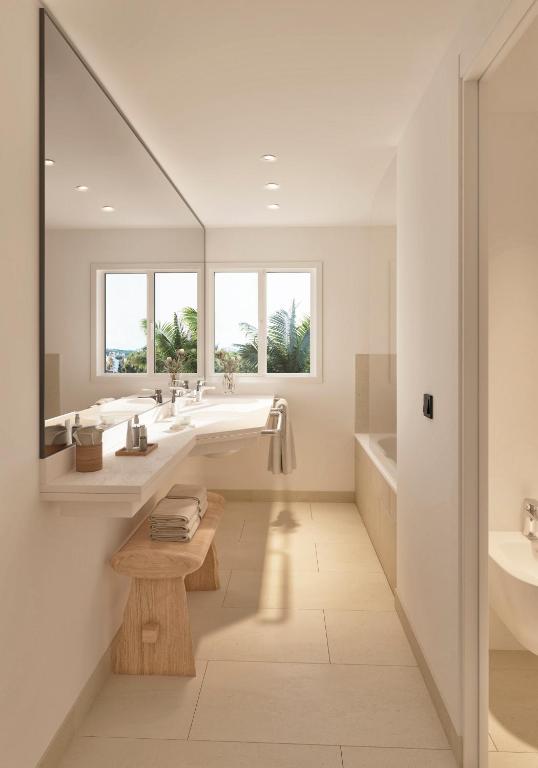 a bathroom with two sinks and a tub and a mirror at Meliá Lloret de Mar in Lloret de Mar