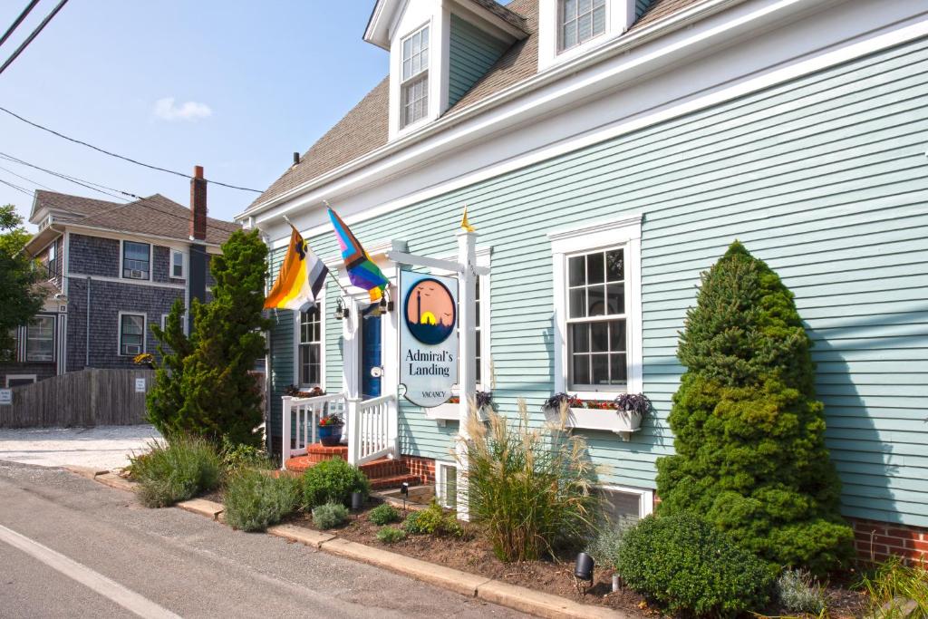 a blue house with flags on the side of it at Admiral's Landing in Provincetown