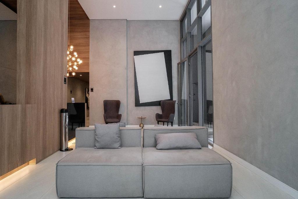 ein Wohnzimmer mit einem Sofa und 2 Stühlen in der Unterkunft Yume Vitrali Studios in São Paulo
