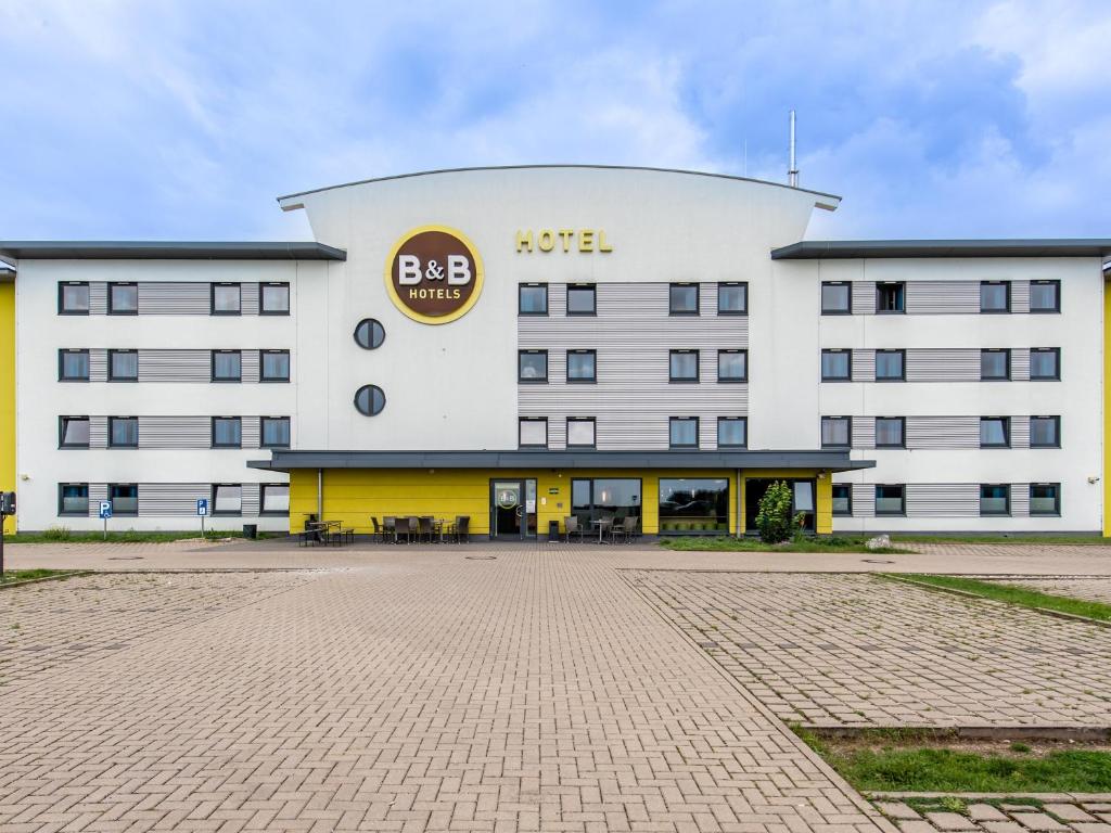 ein großes weißes Gebäude mit einem Schild drauf in der Unterkunft B&B Hotel Erlangen in Erlangen