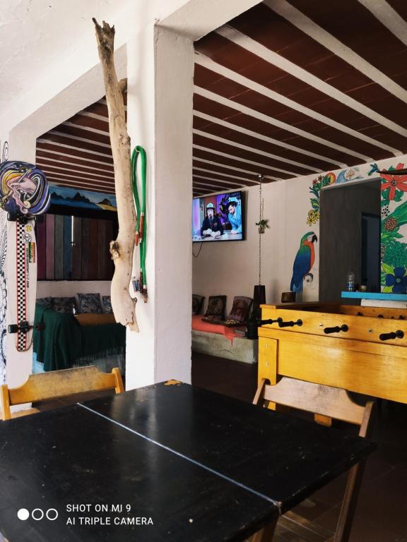 a room with a ping pong table and a living room at Raizes Surf and Bar Hostel in Búzios