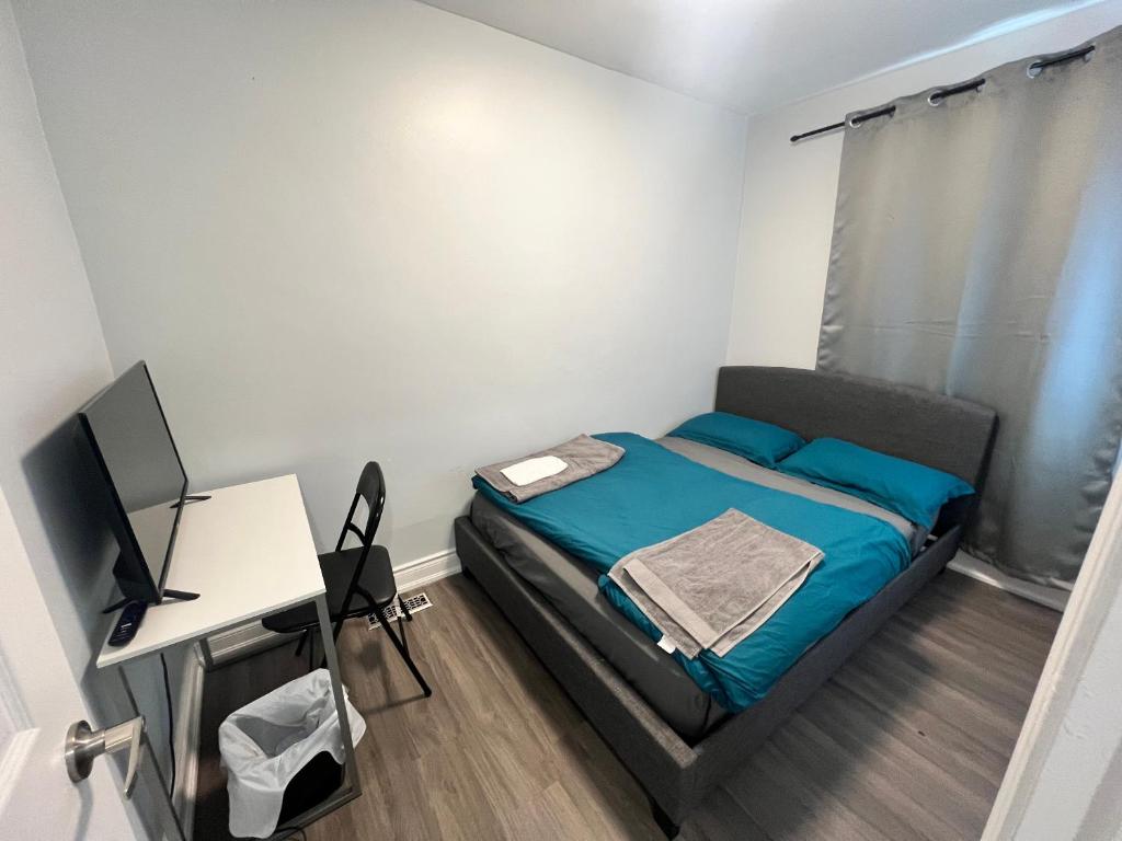 a small bedroom with a bed and a desk at Flowealth Property in Toronto