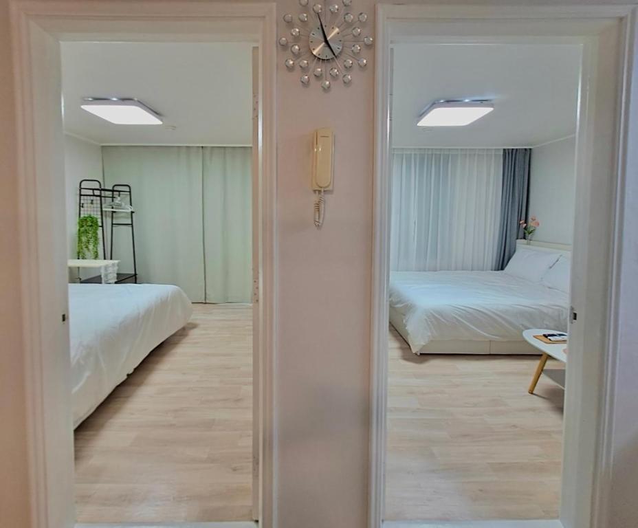 Cette chambre comprend 2 lits et un miroir. dans l'établissement Damso stay, à Séoul