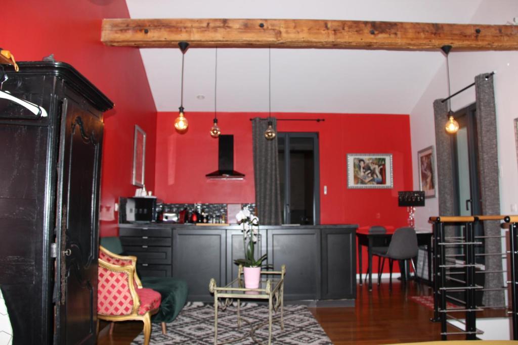 una sala de estar con paredes rojas y una mesa. en PARIS de FLORE Flore en Malakoff