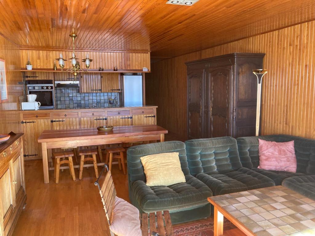 ein Wohnzimmer mit einem Sofa und einem Tisch in der Unterkunft Très bel appartement au cœur de la station in Orcières