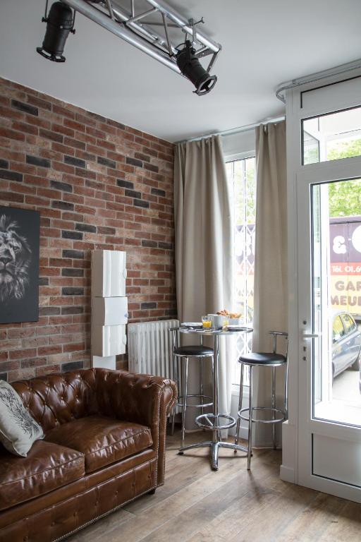 un salon avec un canapé et un mur de briques dans l'établissement Studio Photo face au Parc des Expositions, à Paris